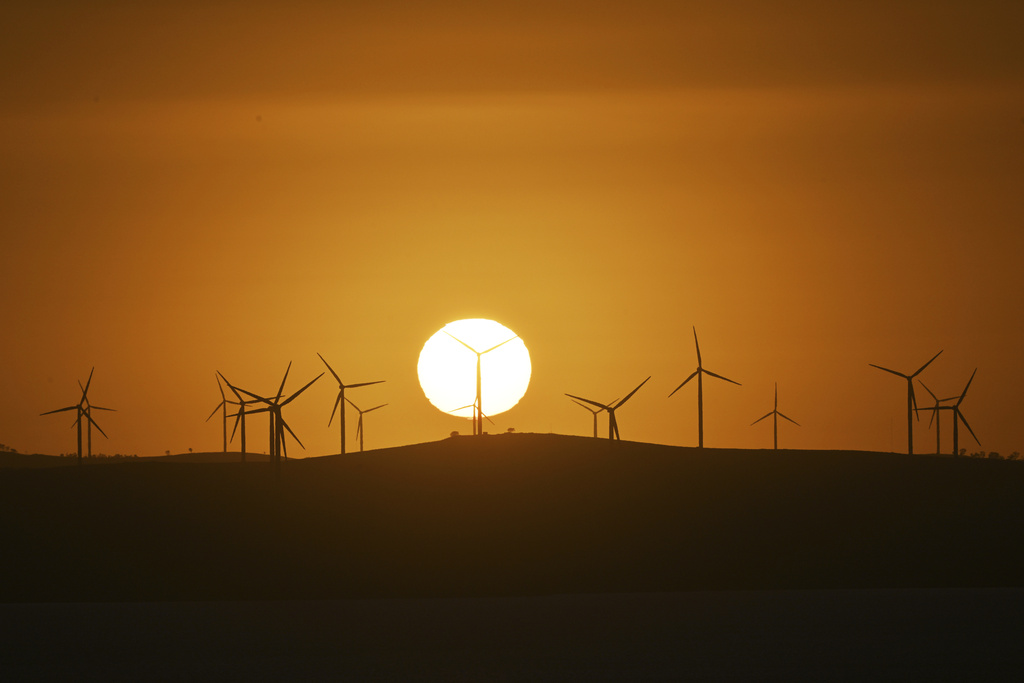 The sun rises over power-generating wind turbines at the Capital Wind Farm near Canberra, Australia, on March 18, 2025. (Mick Tsikas/AAP Image via AP)
