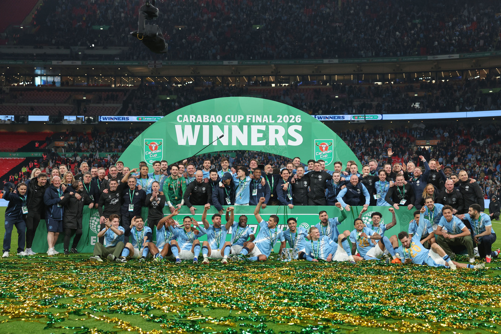 Manchester City players and staff celebrate with the trophy after winning the English League Cup final soccer match between Arsenal and Manchester City in London, Sunday, March 22, 2026. (AP Photo/Richard Pelham)