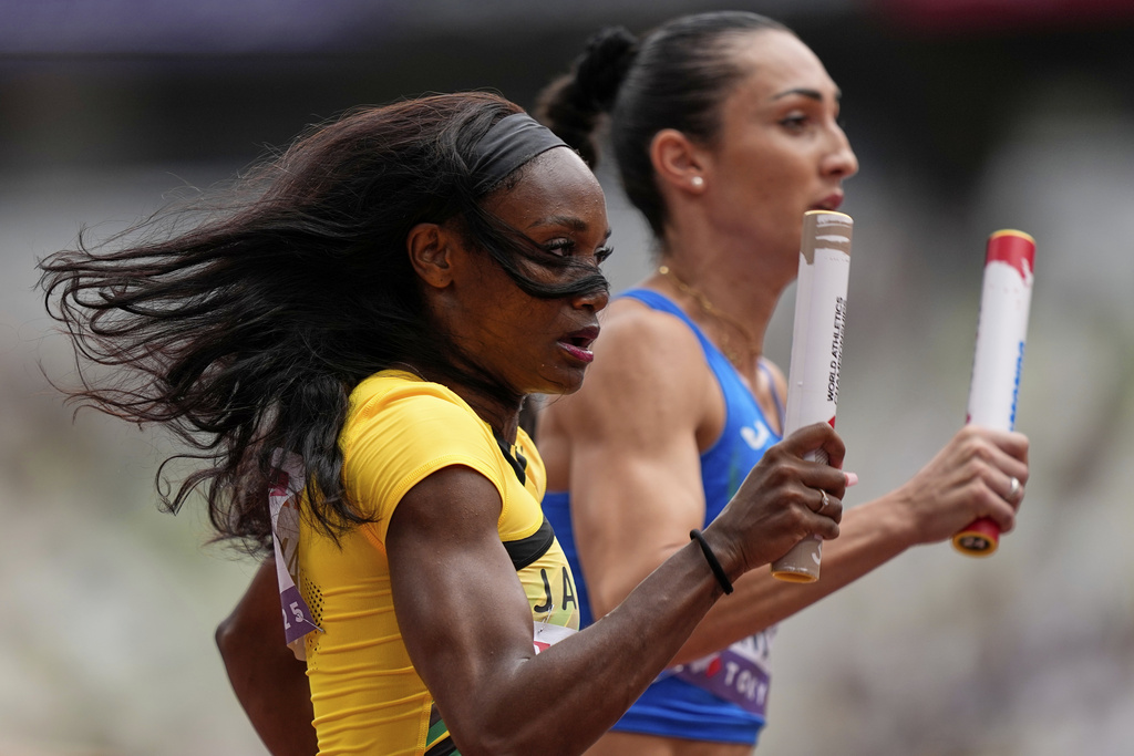 Jamaica's Zandrion Barnes, left, and Italy's Vladimir Aceti compete in a mixed 4 X 400 meters relay heat at the World Athletics Championships in Tokyo, Saturday, Sept. 13, 2025. (AP Photo/Petr David Josek)