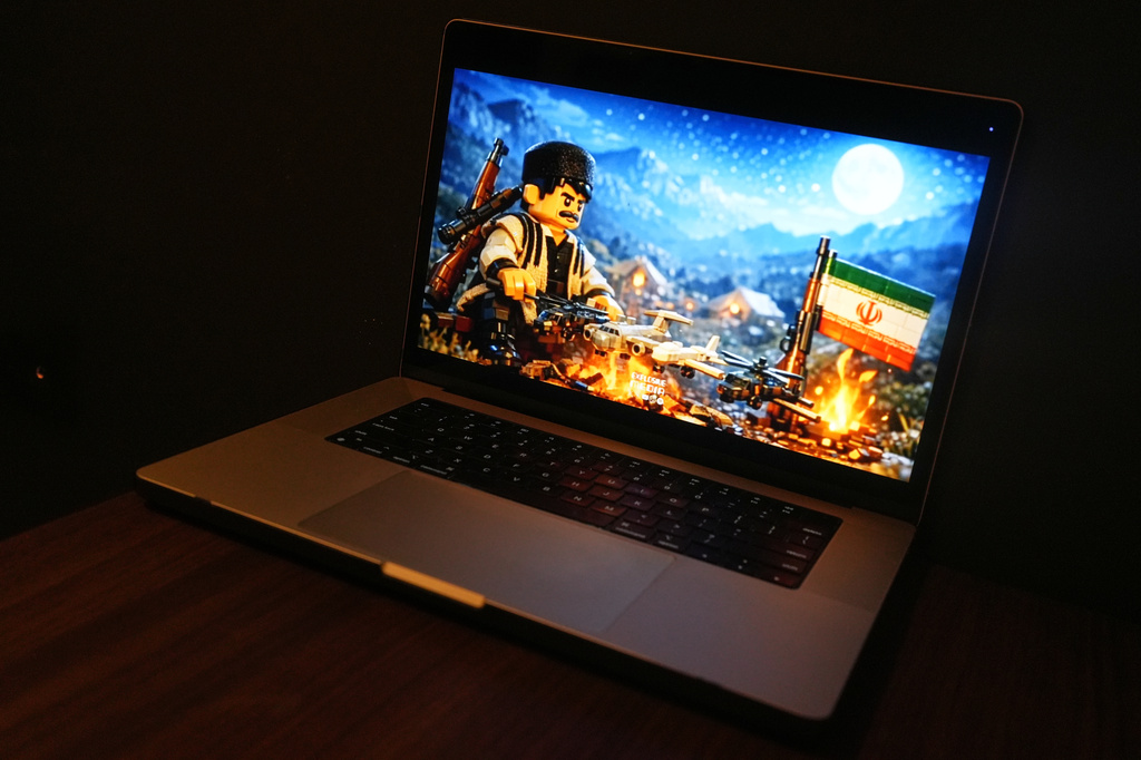 An AI-generated animation created by a pro-Iran studio and depicting an Iranian man grilling four U.S. aircrafts like a kebab over a campfire is seen on a computer screen in Brussels, Wednesday, April 8, 2026. (AP Photo/Sam McNeil)