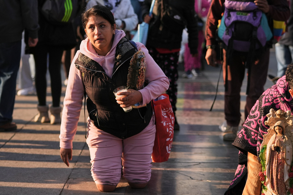 A woman crawls on her knees to the Basilica of Our Lady of Guadalupe in Mexico City, on her feast day, Friday, Dec. 12, 2025. (AP Photo/Claudia Rosel)