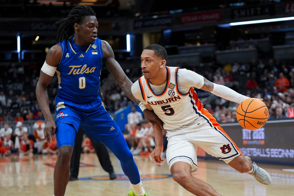 Auburn guard Kaden Magwood (5) drives past Tulsa guard Ade Popoola (0) during the first half of the NCAA college basketball NIT Championship game, Sunday, April 5, 2026, in Indianapolis. (AP Photo/Abbie Parr)