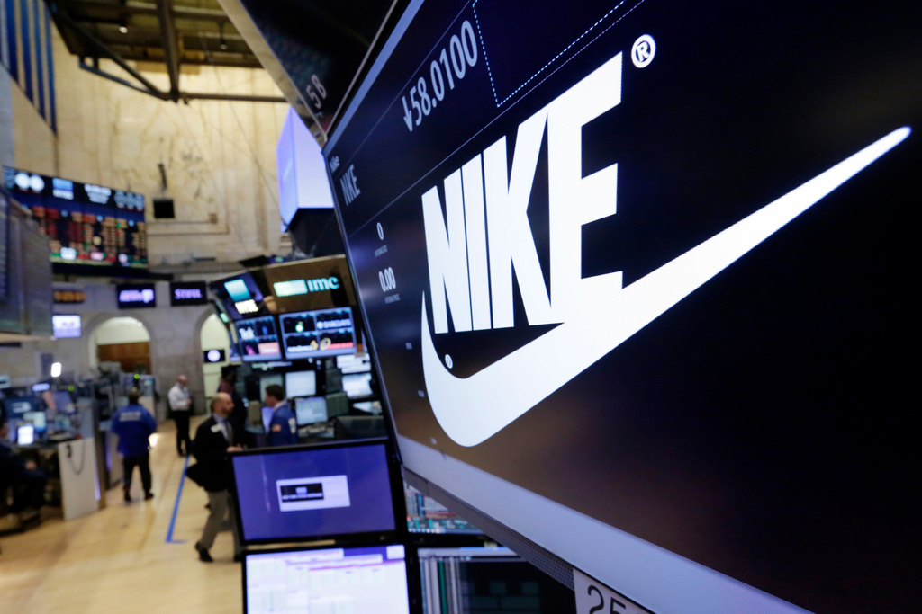 FILE - The Nike logo appears above the post where it trades on the floor of the New York Stock Exchange, March 22, 2017. (AP Photo/Richard Drew, File)