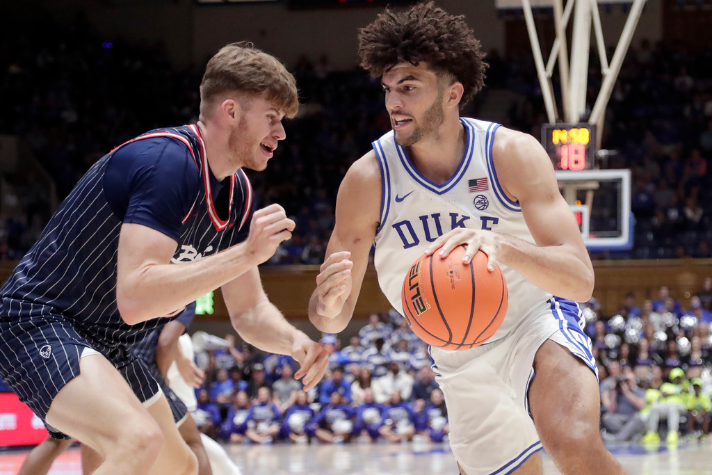 Duke forward Cameron Boozer, right, drives against Howard center Danas Kazakevicius, left, during the second half of an NCAA college basketball game, Sunday, Nov. 23, 2025, in Durham, N.C. (AP Photo/Chris Seward)
