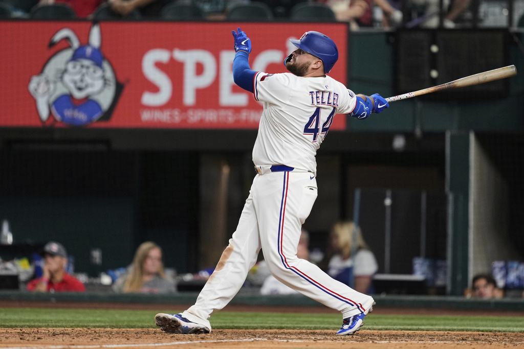 Texas Rangers' Rowdy Tellez follows through on a solo home run swing in the ninth inning of a baseball game against the Arizona Diamondbacks Monday, Aug. 11, 2025, in Arlington, Texas. (AP Photo/Tony Gutierrez)
