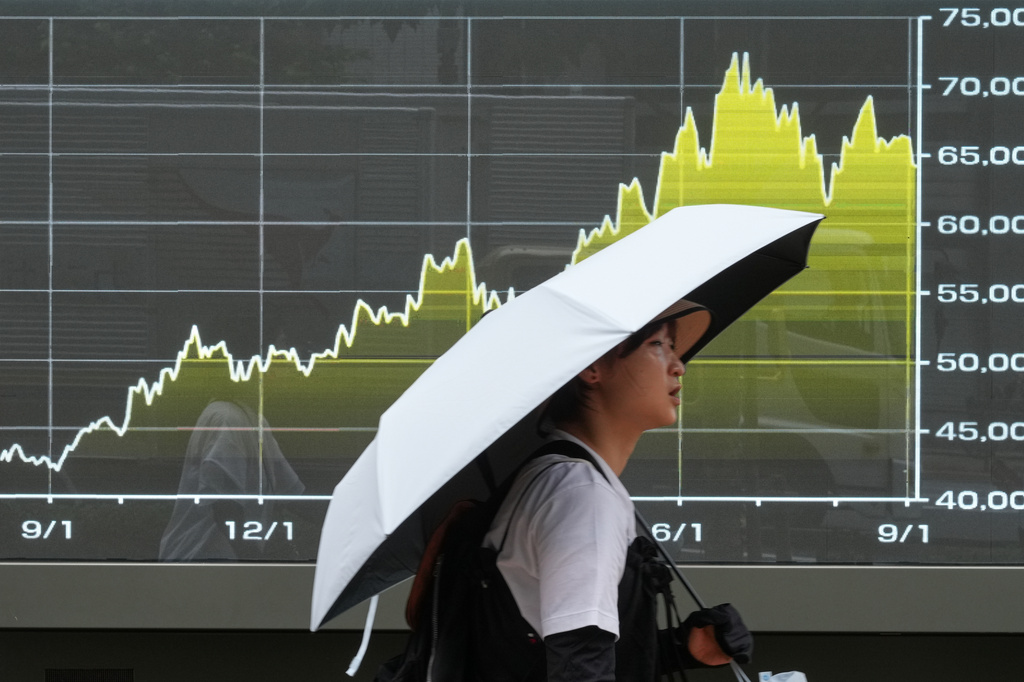 A person walks in front of an electronic stock board showing Japan's Nikkei index at a securities firm Friday, Sept. 4, 2026, in Tokyo. (AP Photo/Eugene Hoshiko)