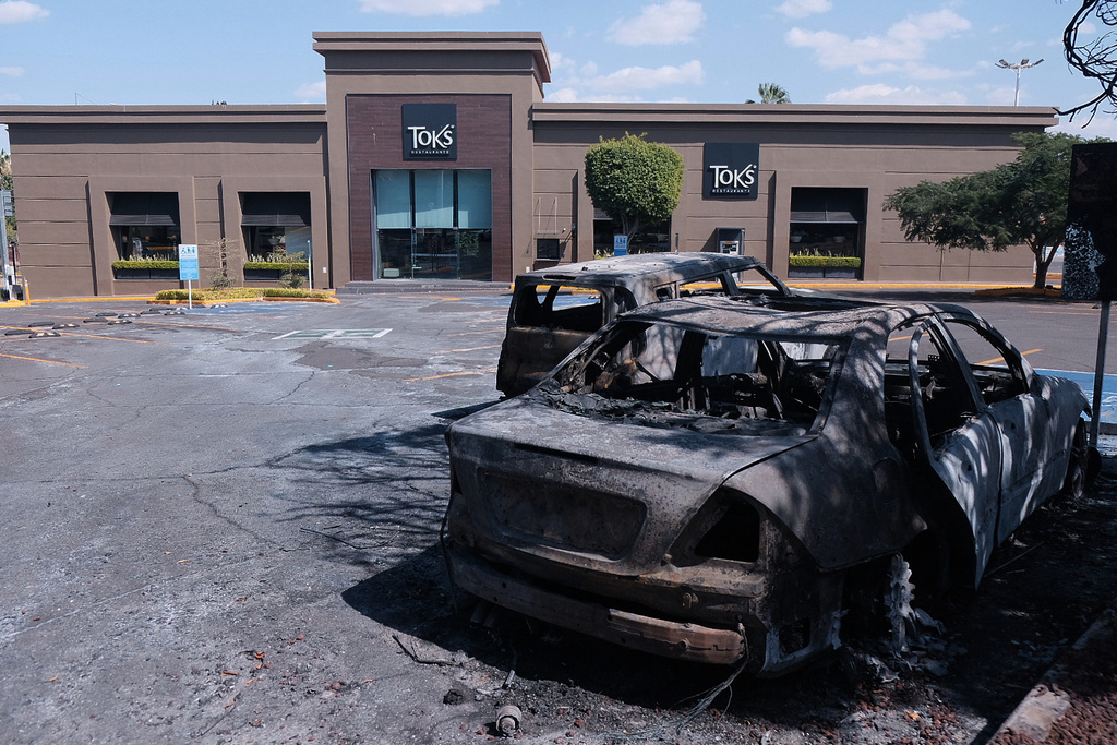 Charred vehicles sit in a parking lot outside a shopping mall in Guadalajara, Jalisco state, Mexico, Sunday, Feb. 22, 2026, as authorities reported that the Mexican Army killed Jalisco New Generation Cartel leader Nemesio Oseguera Cervantes, known as "El Mencho." (AP Photo/Alejandra Leyva)