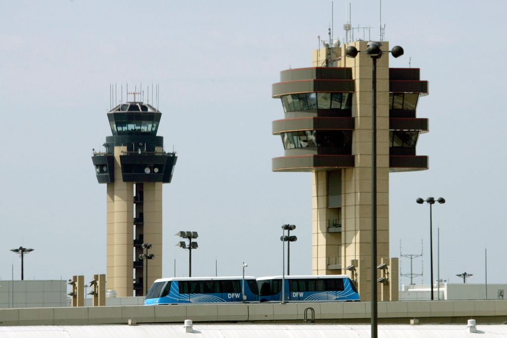 FILE - A Skylink tram passes in front of control towers at the Dallas-Fort Worth International Airport in Grapevine, Texas, on Sunday, Aug. 10, 2008. (AP Photo/Matt Slocum, File)