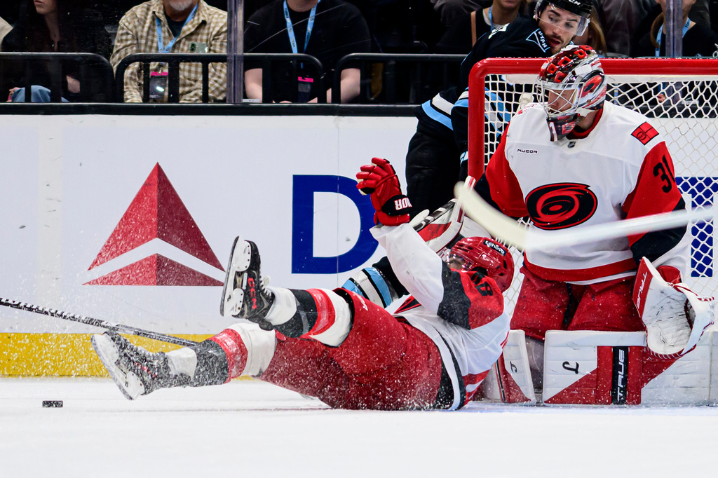 Carolina Hurricanes left wing Jordan Martinook, left, slides to block the puck during the first period of an NHL hockey game against the Utah Mammoth, Saturday, April 11, 2026, in Salt Lake City. (AP Photo/Tyler Tate)