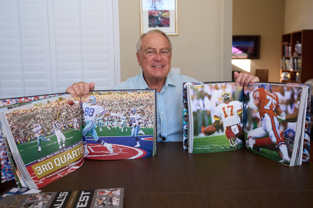 Photographer John Biever, who has shot every Super Bowl NFL football game, holds images he has made from previous bowl games at his home Tuesday, Jan. 20, 2026, in San Diego. (AP Photo/Gregory Bull)