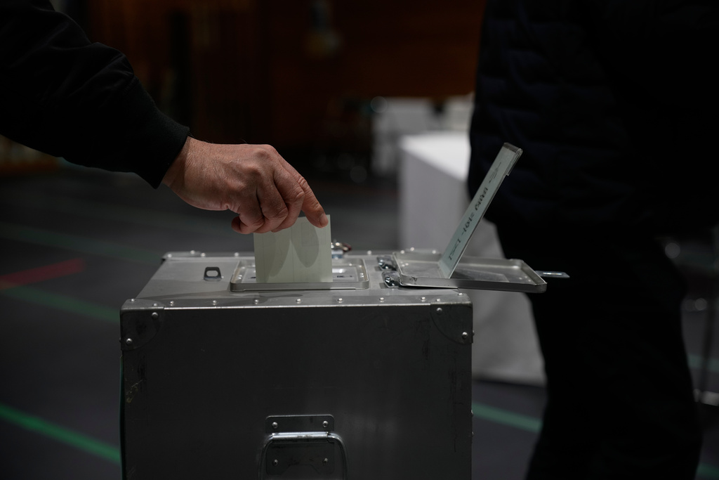 A voter casts a ballot in the lower house election at a polling station Sunday, Feb. 8, 2026, in Tokyo. (AP Photo/Louise Delmotte)