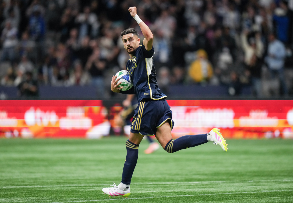 Vancouver Whitecaps' Belal Halbouni celebrates a goal by teammate Brian White against the Portland Timbers during the second half of an MLS soccer match, in Vancouver, British Columbia, Wednesday, Sept. 24, 2025. (Darryl Dyck/The Canadian Press via AP)