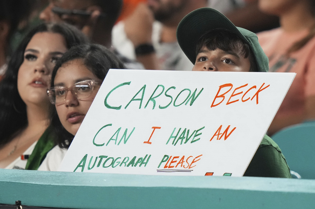 A fan holds a sign for Miami quarterback Carson Beck during the second half of an NCAA college football game against Bethune-Cookman, Saturday, Sept. 6, 2025, in Miami Gardens, Fla. (AP Photo/Lynne Sladky)