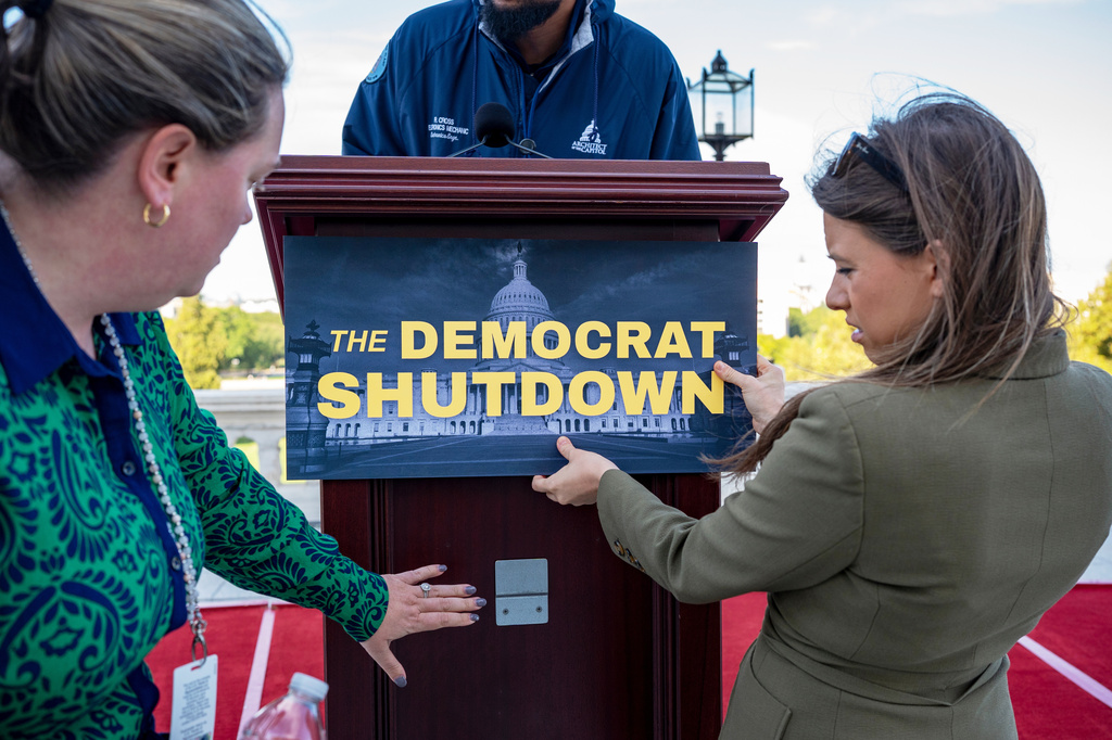 Congressional staff prepare for an event with Speaker of the House Mike Johnson, R-La., and the top Republicans in Congress on the first day of the government shutdown, at the Capitol in Washington, Wednesday, Oct. 1, 2025. (AP Photo/J. Scott Applewhite)