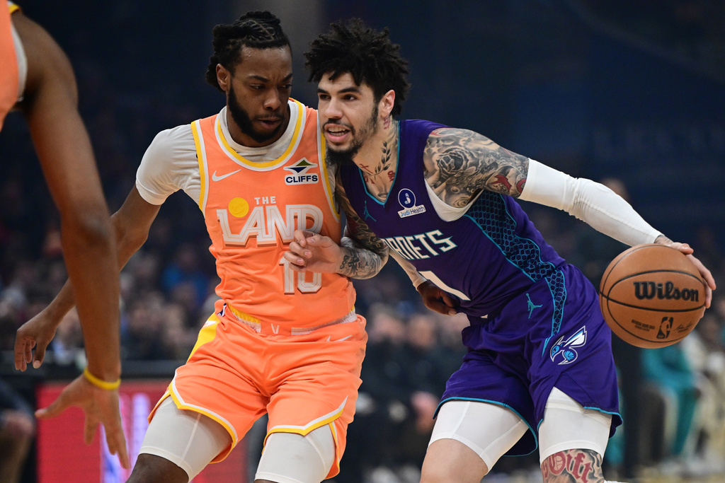 Charlotte Hornets guard Lamelo Ball, right, drives against Cleveland Cavaliers guard Darius Garland, left, in the first half of an NBA basketball game, Monday, Dec. 22, 2025, in Cleveland. (AP Photo/David Dermer)