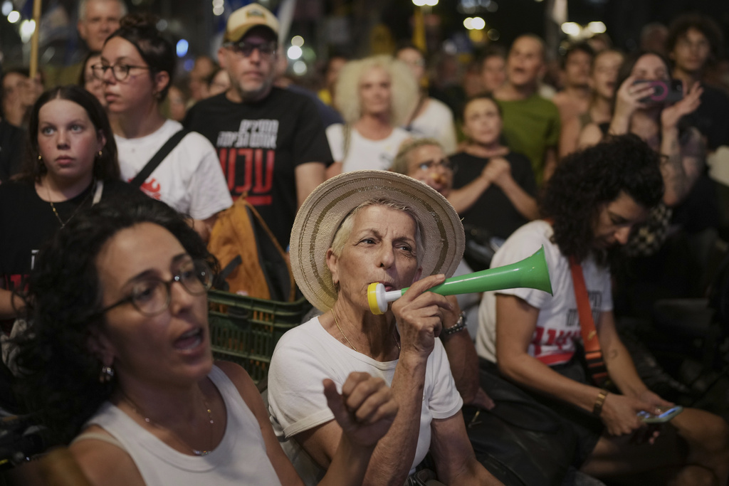 Demonstrators march during a protest demanding the immediate release of hostages held by Hamas and calling for the Israeli government to reverse its decision to take over Gaza City and other areas in the Gaza Strip, in Tel Aviv, Israel, Sunday, Aug. 17, 2025. (AP Photo/Ohad Zwigenberg)