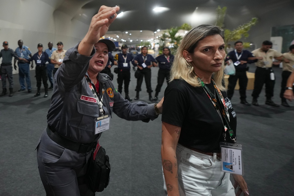 Security officials direct attendees to leave the venue for the COP30 U.N. Climate Summit, Thursday, Nov. 20, 2025, in Belem, Brazil. (AP Photo/Andre Penner)