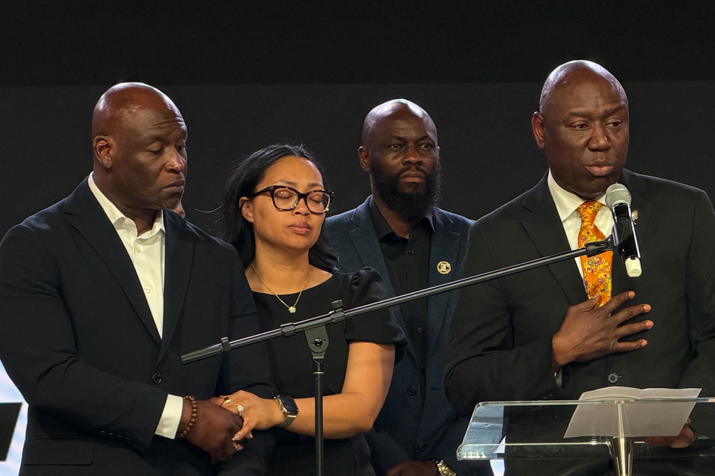 In this photo taken with a smartphone, Ben Crump, right, an attorney for the family of Nolan Wells, speaks at a news conference in Stonecrest, Ga., Thursday, Sept. 22, 2026, accompanied by Wells' parents, Elmore and Christine Wonsley. (AP Photo/Emilie Megnien)