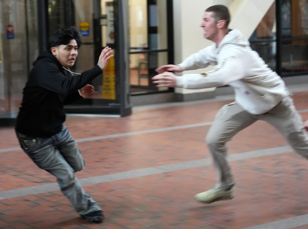 Plain clothed federal agents pursue a man through the lobby of the Hennepin County Government Center in Minneapolis before tackling and arresting him, on Tuesday, Feb. 10, 2026. (Anthony Souffle/Star Tribune via AP)
