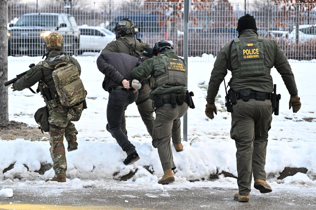 Federal agents confront protesters outside the Bishop Henry Whipple Federal Building, Thursday, Jan. 8, 2026, in Minneapolis, Minn. (AP Photo/Tom Baker)