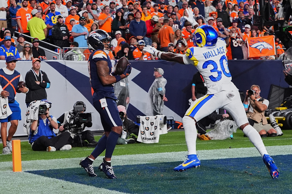 Denver Broncos wide receiver Jaylen Waddle, left, catches a touchdown pass against Los Angeles Rams cornerback Josh Wallace during the second half of an NFL football game Sunday, Sept. 27, 2026, in Denver. (AP Photo/David Zalubowski)