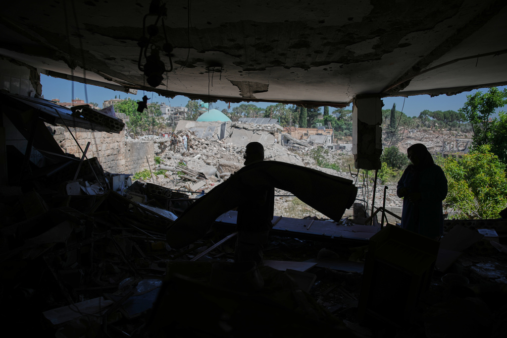 Mahasen Faqih and her husband, Mohammed Sobeih, stand inside their destroyed home overlooking the rubble of their neighborhood after returning to it following the Israeli military operation in Zawtar al-Gharbieh, Lebanon, Tuesday, July 28, 2026. (AP Photo/Hassan Ammar)