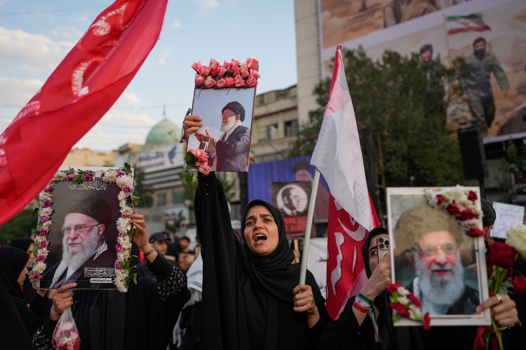 Mourners chant while holding flower-framed portraits of the slain Iranian Supreme Leader Ayatollah Ali Khamenei during Khamenei's funeral procession in Tehran, Iran, Monday, July 6, 2026. (AP Photo/Altaf Qadri)