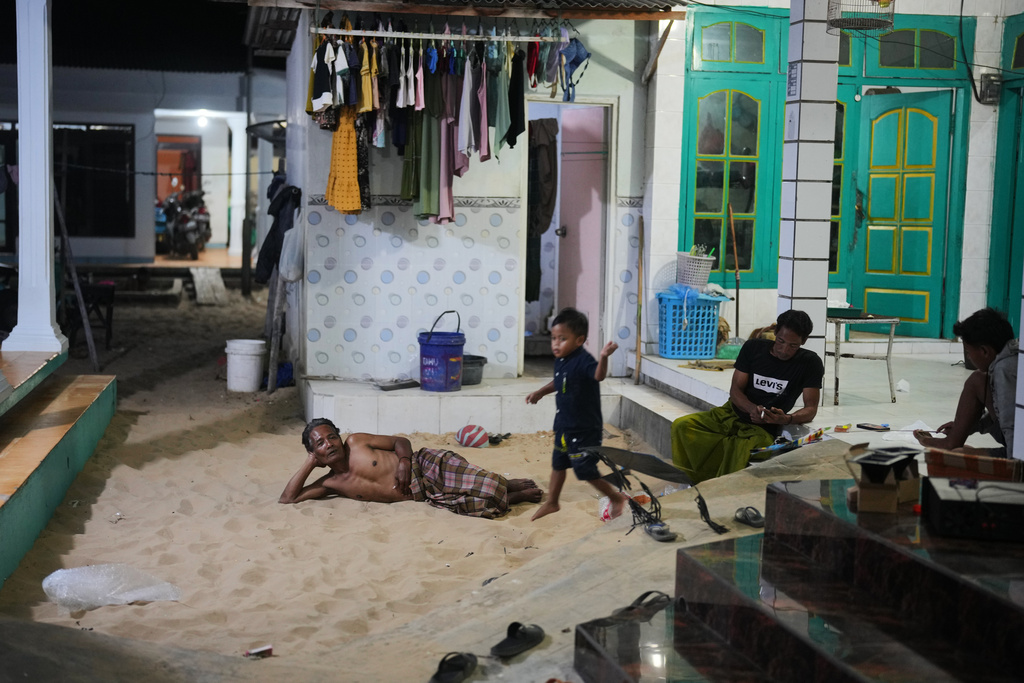 A man lies in a sandpit which is available in almost every house in Legung Timur village in Sumenep on Madura Island, Indonesia, Tuesday, Sept. 9, 2025. (AP Photo/Dita Alangkara)