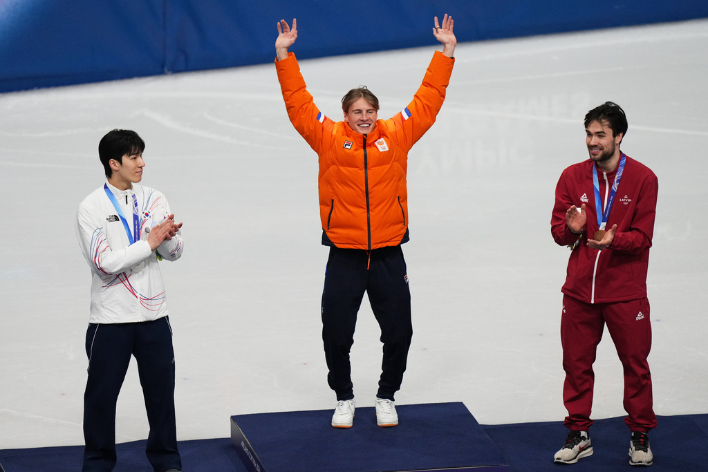 Gold medalist Jens van 't Wout of the Netherlands jumps on the podium to receive his medal after the short track speed skating men's 1500m at the 2026 Winter Olympics, in Milan, Italy, Saturday, Feb. 14, 2026. (AP Photo/Francisco Seco)
