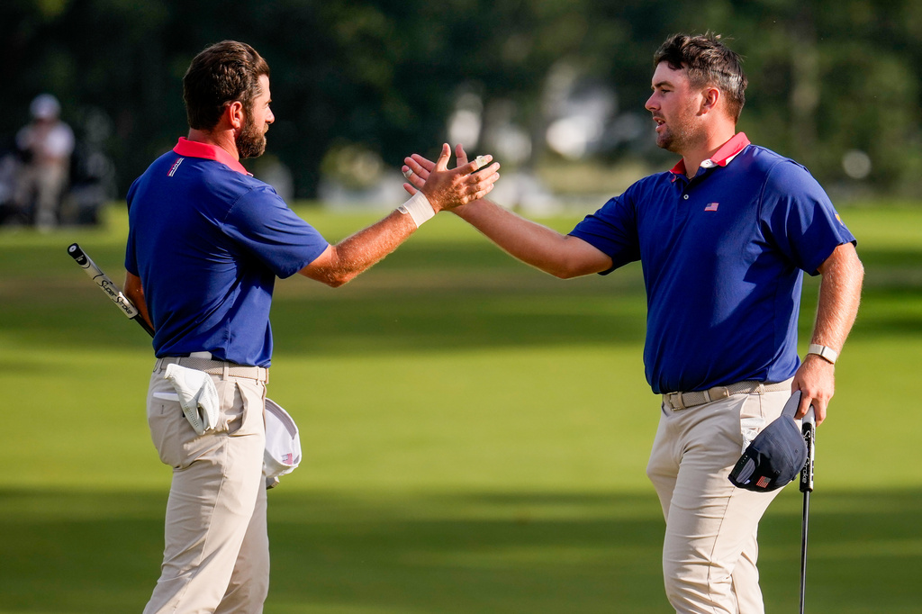 USA teams' Chris Gotterup, right, celebrates with Cameron Young after defeating the International team after their Presidents Cup golf tournament third round foursome match at Medinah Country Club, Saturday, Sept. 26, 2026, in Medinah, Ill. (AP Photo/Matt Slocum)