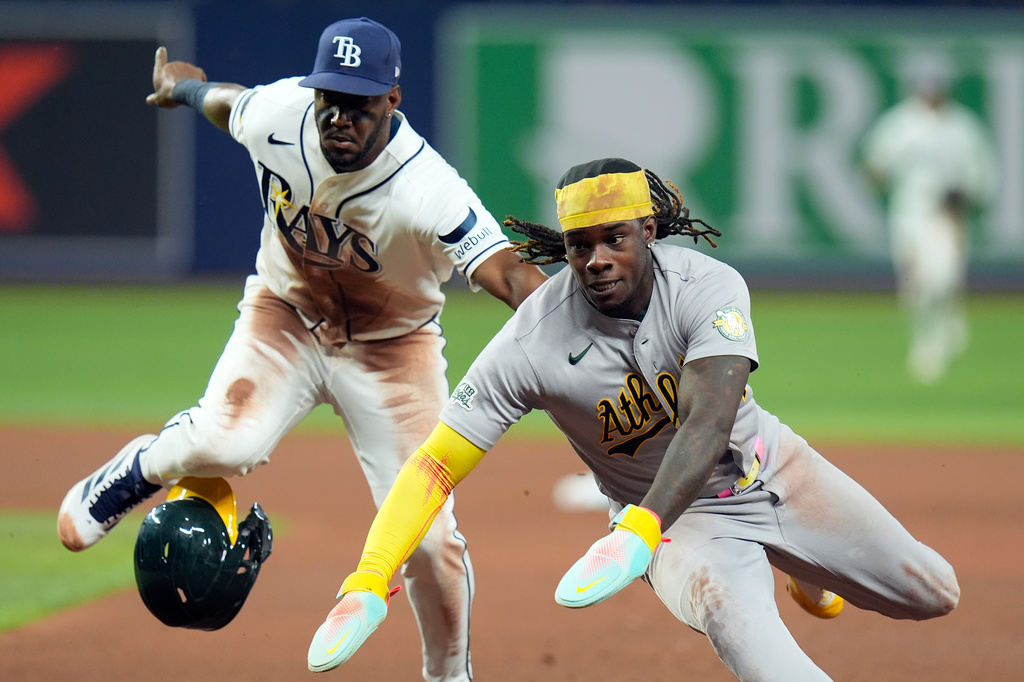 Athletics' Lawrence Butler, right, gets tagged out by Tampa Bay Rays shortstop Jorge Mateo after getting caught in a run down on a ground out by Donovan Walton during the fourth inning of a baseball game Wednesday, Sept. 16, 2026, in St. Petersburg, Fla. (AP Photo/Chris O'Meara)