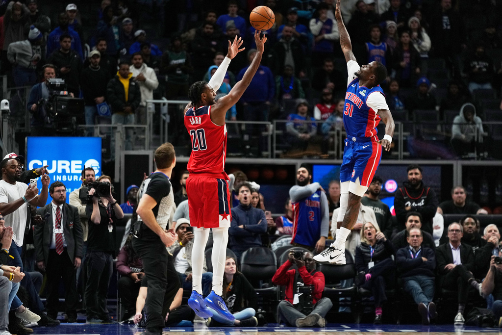 Washington Wizards center Alex Sarr, left, shoots against Detroit Pistons guard Javonte Green during overtime in an NBA basketball game Monday, Nov. 10, 2025, in Detroit. (AP Photo/Ryan Sun)