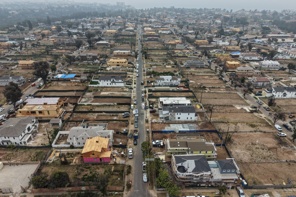 An aerial view shows homes under construction amid empty lots more than a year after the Palisades Fire in the Pacific Palisades neighborhood of Los Angeles, Thursday, June 4, 2026. (AP Photo/Jae C. Hong)