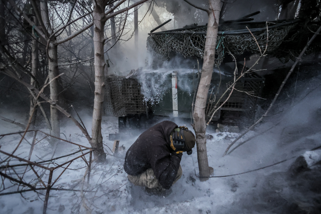 In this photo provided by Ukraine's 24th Mechanized Brigade press service, servicemen fire a 2S1 Gvozdika self propelled howitzer towards Russian positions near Chasiv Yar town, Donetsk region, Ukraine, Sunday, Jan. 18, 2026. (Oleg Petrasiuk/Ukraine's 24th Mechanized Brigade via AP)
