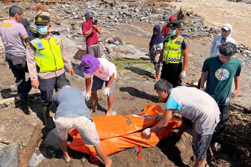Rescuers put the body of a flood victim recovered from a river inside a body bag in Padang Pariaman, West Sumatra, Indonesia, Saturday, Nov. 29, 2025. (AP Photo/Ade Yuandha)