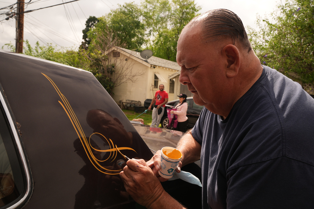 Freehand and pinstriping artist Danny Alvarado works on a lowrider at his workshop in Monrovia, Calif., Tuesday, March 10, 2026. (AP Photo/Damian Dovarganes)