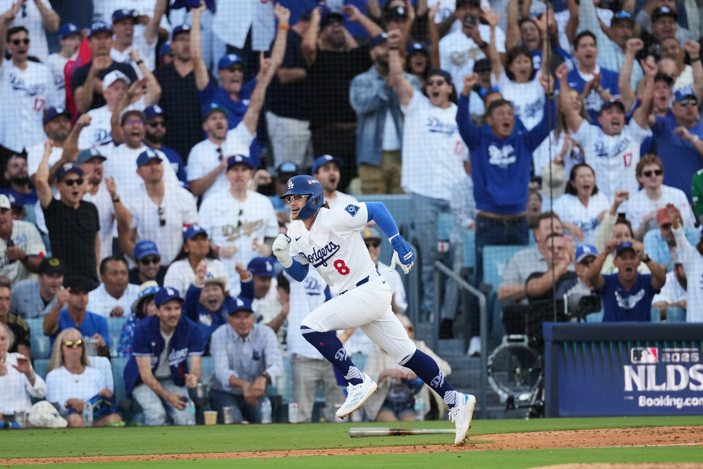 El puertorriqueño Kike Hernández de los Dodgers de Los Ángeles corre a primera base con un sencillo durante la séptima entrada en el Juego 4 de la Serie Divisional de la Liga Nacional de béisbol contra los Filis de Filadelfia, el jueves 9 de octubre de 2025, en Los Ángeles. (AP Photo/Jae C. Hong)