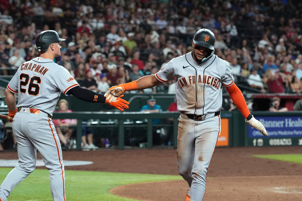 San Francisco Giants' Victor Bericoto, right, celebrates his run scored against the Arizona Diamondbacks with Giants' Matt Chapman (26) during the fifth inning of a baseball game, Monday, June 29, 2026, in Phoenix. (AP Photo/Ross D. Franklin)