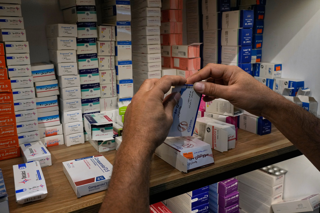 A pharmacy worker arranges boxes of medicine on shelves at a pharmacy in Tehran, Iran, Monday, Sept. 21, 2026. (AP Photo/Vahid Salemi)