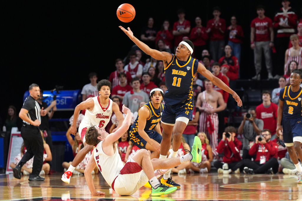 Toledo's Will James Jr., center, collects a loose ball against Miami's (OH) Peter Suder, bottom, during the first half of an NCAA college basketball game, Tuesday, March 3, 2026, in Oxford, Ohio. (AP Photo/Kareem Elgazzar)