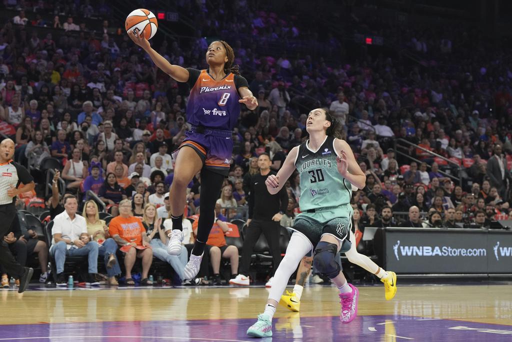Phoenix Mercury guard Monique Akoa Makani (8) drives past New York Liberty forward Breanna Stewart (30) during the first half of Game 3 in the first round of the WNBA basketball playoffs, Friday, Sept. 19, 2025, in Phoenix. (AP Photo/Rick Scuteri)