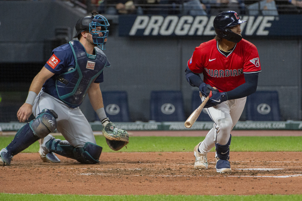 Cleveland Guardians' Bo Naylor, right, watches his RBI single off Seattle Mariners starting pitcher Logan Gilbert along with catcher Cal Raleigh during the fourth inning of a baseball game, Saturday, Aug. 30, 2025, in Cleveland. (AP Photo/Phil Long)