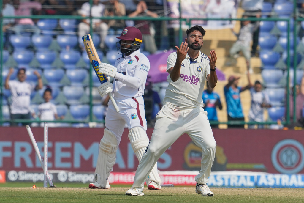 India's Mohammed Siraj celebrates the dismissal of West Indies' Jomel Warrican, left, on the third day of the second cricket test match between India and West Indies at the Arun Jaitley Stadium in New Delhi, India, Sunday, Oct.12, 2025. (AP Photo/Manish Swarup)