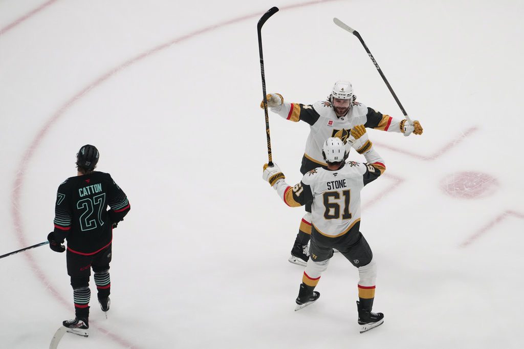 Vegas Golden Knights right wing Mark Stone (61) celebrates his goal with defenseman Rasmus Andersson (4) as Seattle Kraken center Berkly Catton (27) looks on during the first period of an NHL hockey game Thursday, April 9, 2026, in Seattle. (AP Photo/Lindsey Wasson)