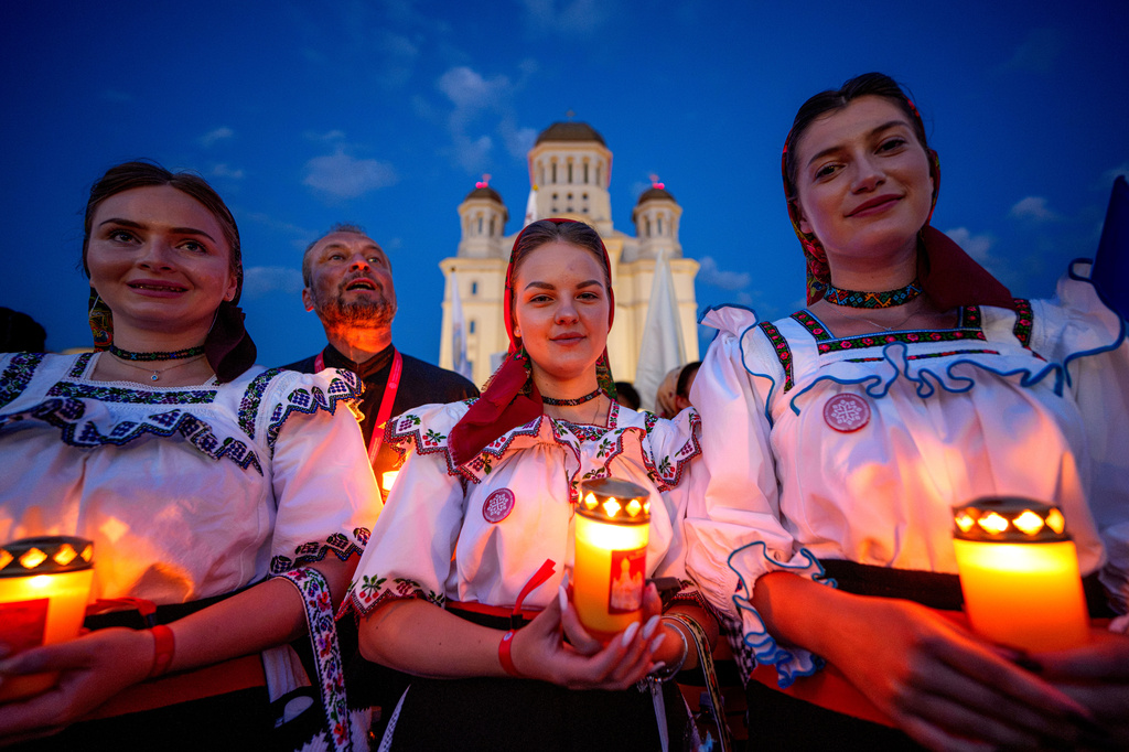 Young women wearing traditional outfits hold candles during the Procession of Lights, part of a four-day program of the International Meeting of Orthodox Youth (ITO), in Bucharest, Romania, Wednesday, Sept. 2, 2026. (AP Photo/Andreea Alexandru)