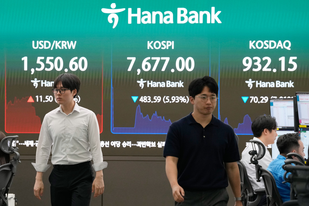 Currency traders pass by a screen showing the Korea Composite Stock Price Index (KOSPI) and the foreign exchange rate between U.S. dollar and South Korean won at the foreign exchange dealing room of the Hana Bank headquarters in Seoul, South Korea, Monday, June 8, 2026. (AP Photo/Ahn Young-joon)
