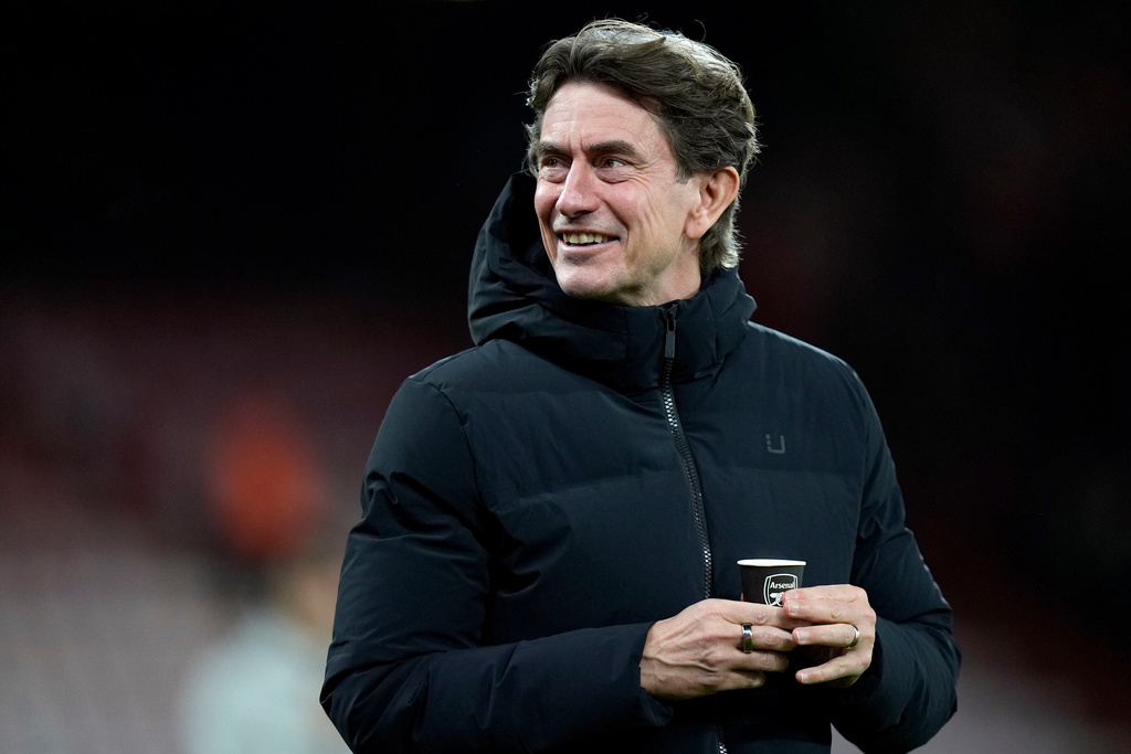 Tottenham Hotspur manager Thomas Frank holds a coffee cup bearing the Arsenal logo as he walks on the pitch before the English Premier League soccer match between Bournemouth and Tottenham Hotspur in Bournemouth, England, Wednesday Jan. 7, 2026. (Andrew Matthews/PA via AP)