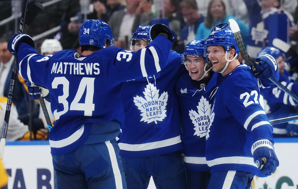 Toronto Maple Leafs' Gavin McKenna (second right) celebrates his goal against the Nashville Predators with Auston Matthews, left to right, Chris Tanev and Jake McCabe during the second period of an NHL hockey game in Toronto, Tuesday, Oct. 6, 2026. (Nathan Denette/The Canadian Press via AP)