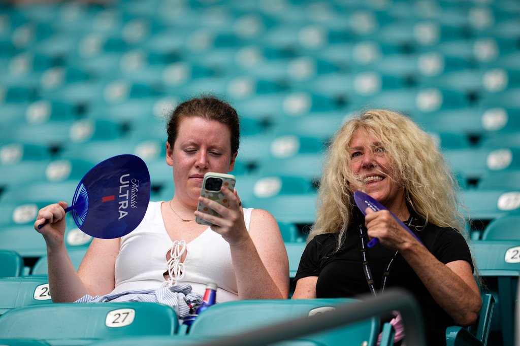 Spectators fan themselves before the World Cup quarterfinal soccer match between Norway and England in Miami Gardens, Fla., Saturday, July 11, 2026. (AP Photo/George Walker IV)