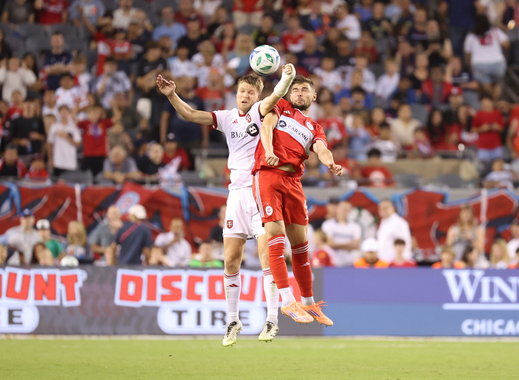 Toronto FC defender Sigurd Rosted, left, and Chicago Fire forward Hugo Cuypers, right, battle for control of the ball during the second half of an MLS soccer match Saturday, Oct. 4, 2025, in Chicago. (AP Photo/Talia Sprague)
